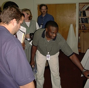 Drew Obeng, a student from University of Central Florida, explains his poster to a judge.  Randy Debasa (left), a student from Florida International University, collaborated with Drew on their supercomputing project.